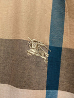 Burberry embroidered crest logo on beige and blue plaid fabric