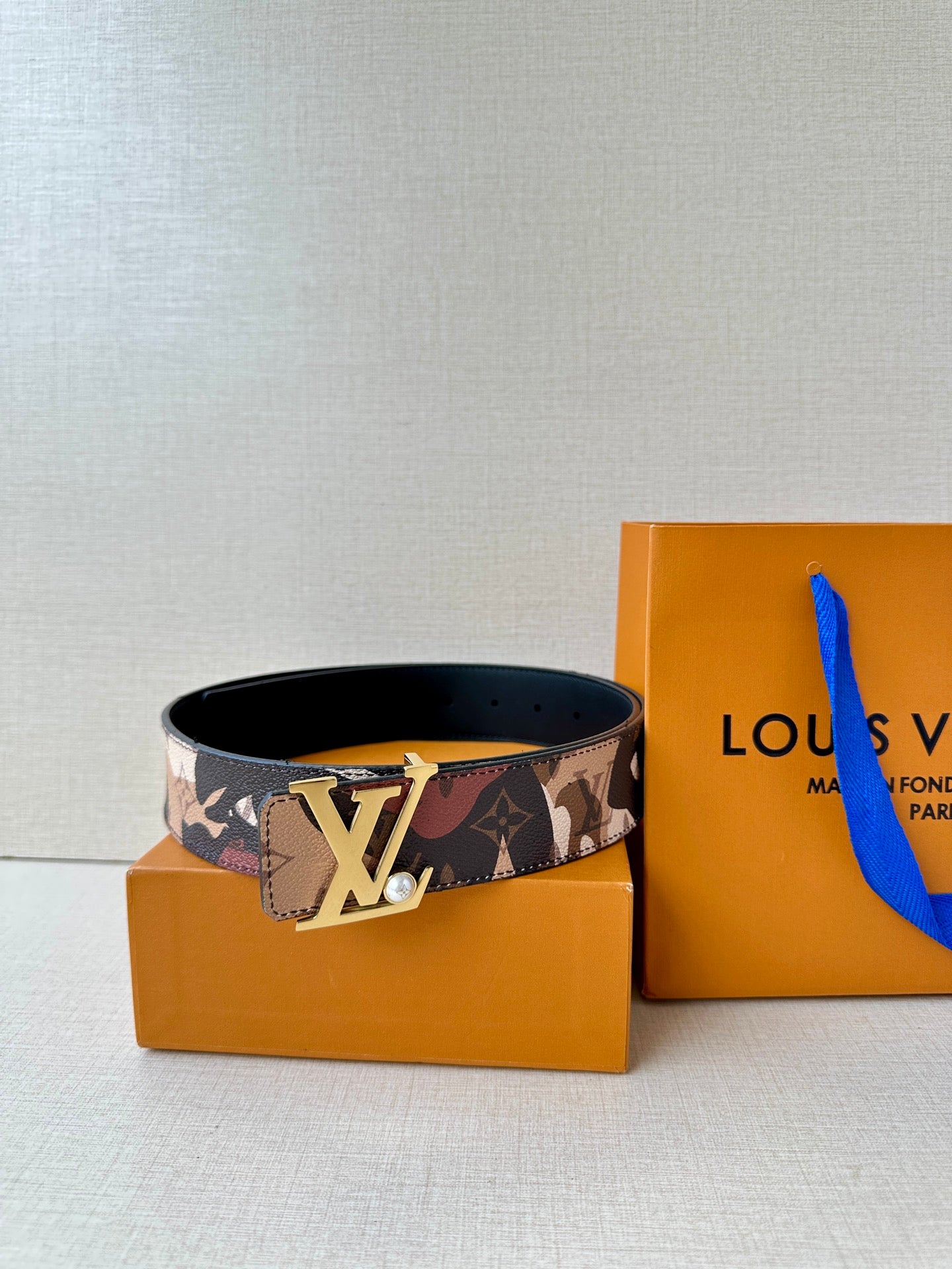 Printed monogram belt with gold-toned LV buckle on patterned strap