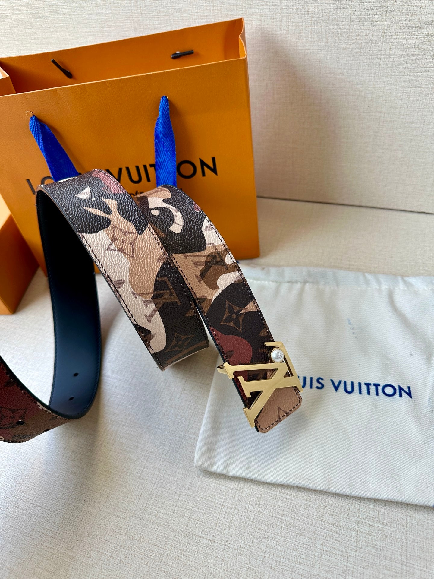Printed monogram belt with gold-toned LV buckle and patterned strap end