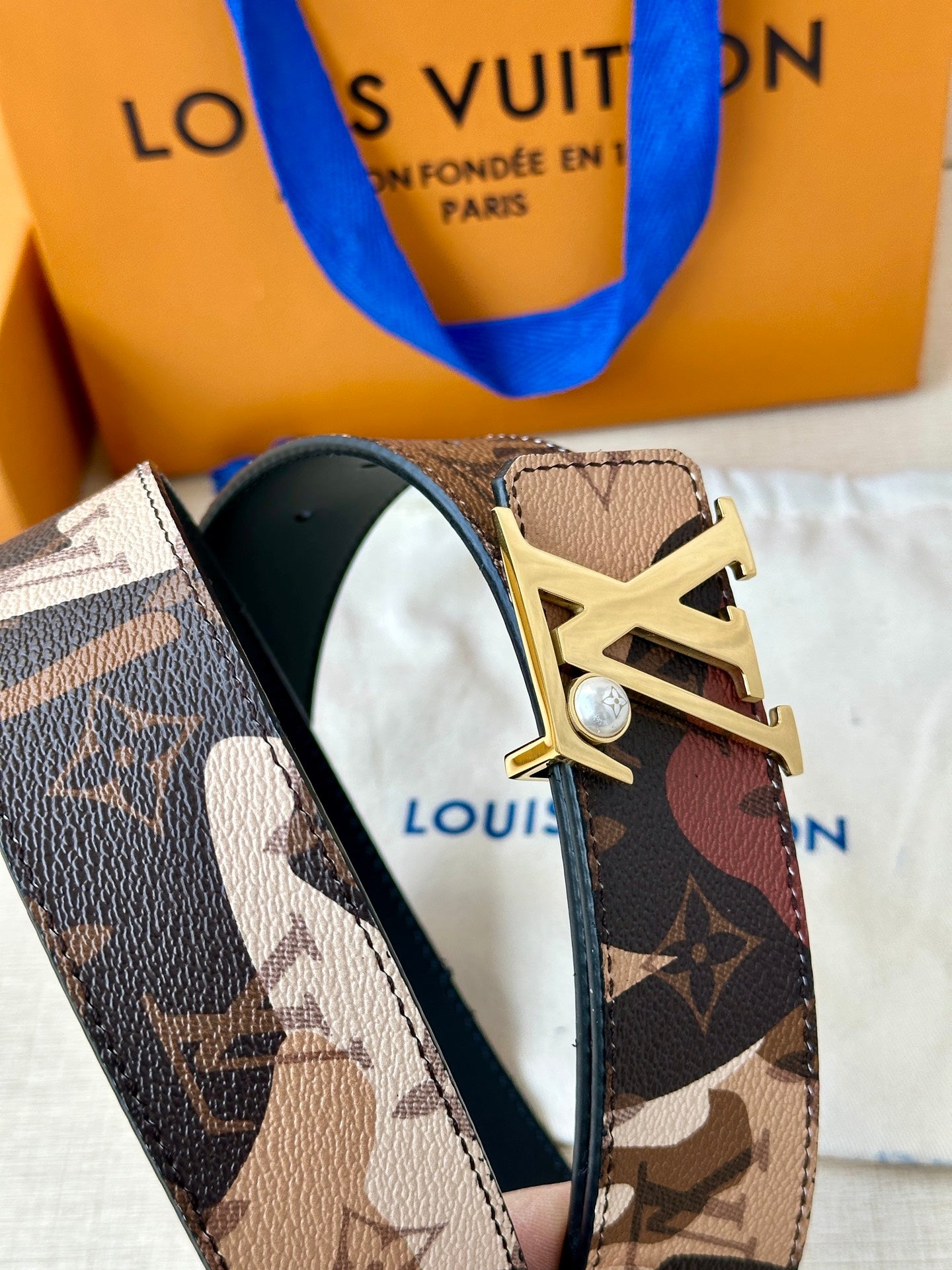 Monogram belt with gold-toned LV buckle and dark underside strap