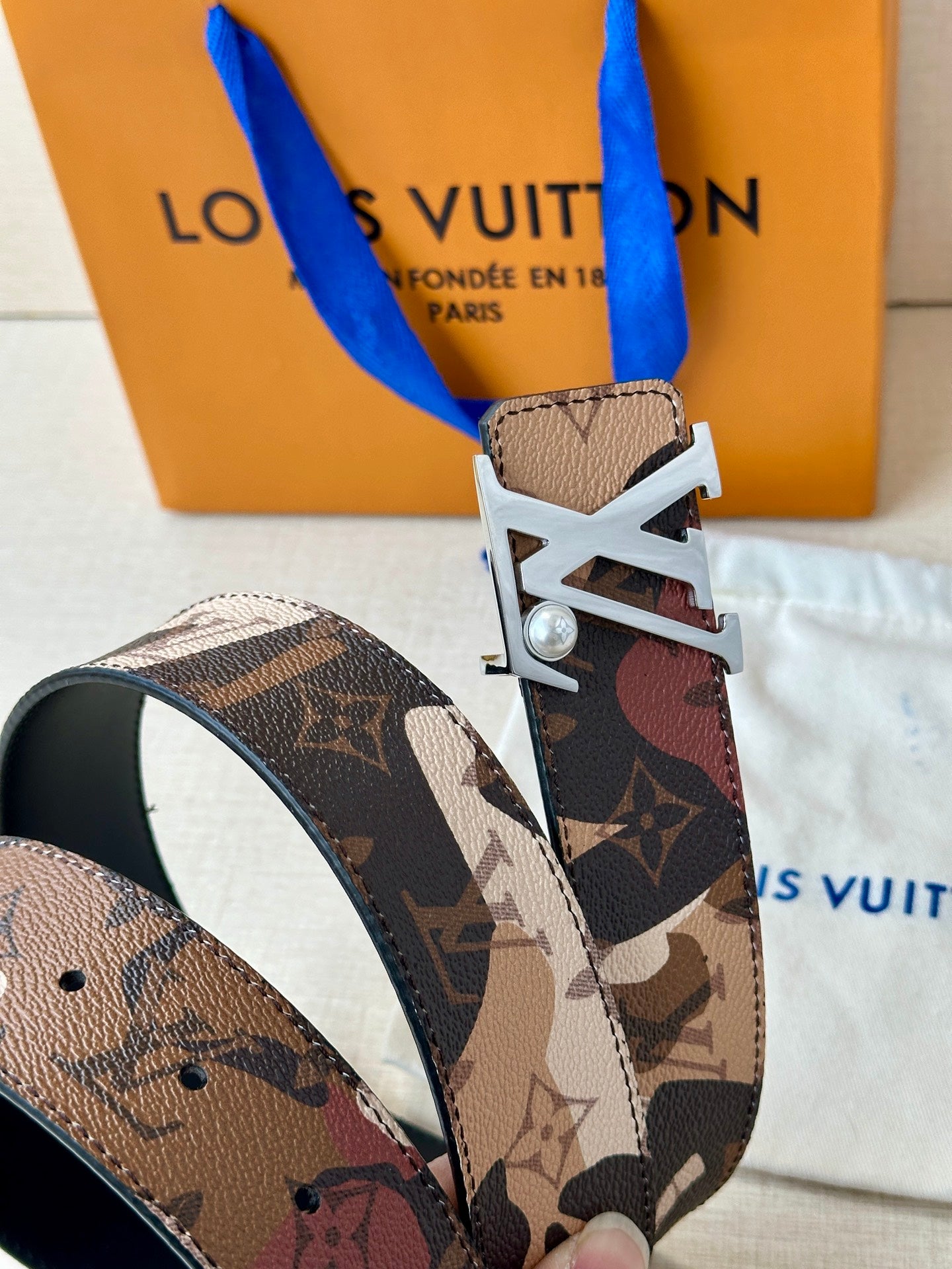 Monogram belt with silver-toned LV buckle and patterned strap, visible buckle detail