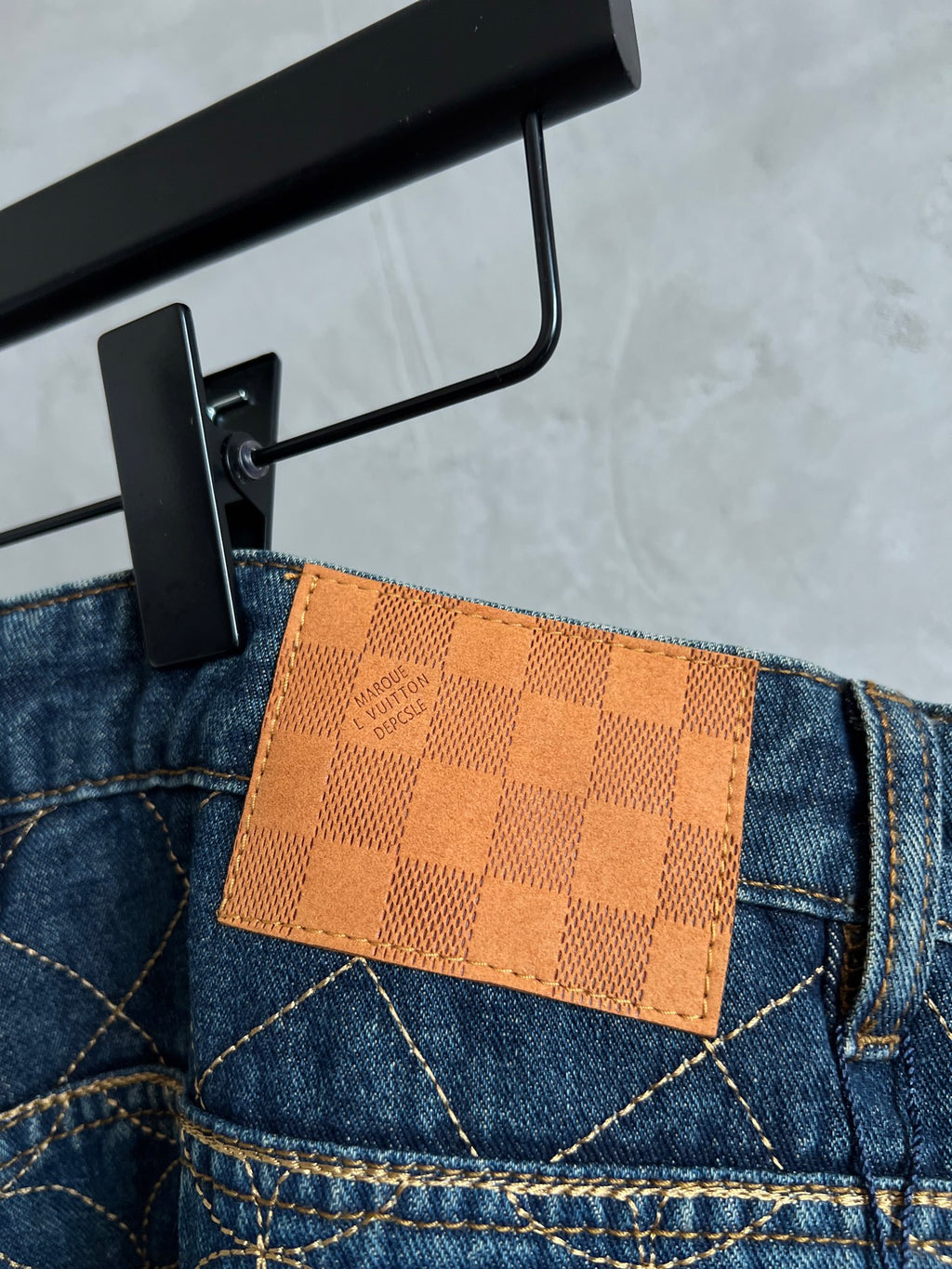 Dark blue denim back pocket with tan check leather patch
