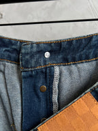 Dark blue denim waistband with coin pocket button and tan/gold contrast stitching