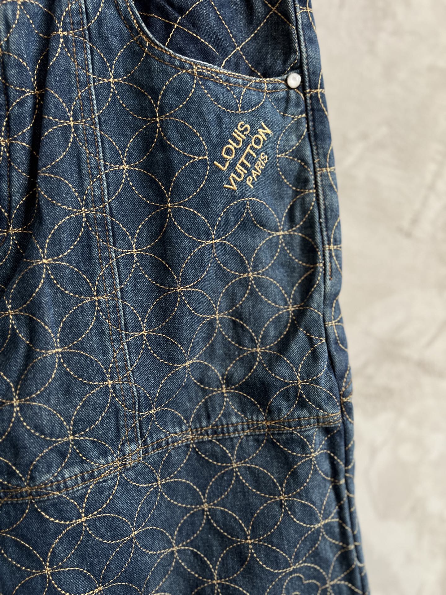 Dark blue denim pants with gold geometric flower embroidery