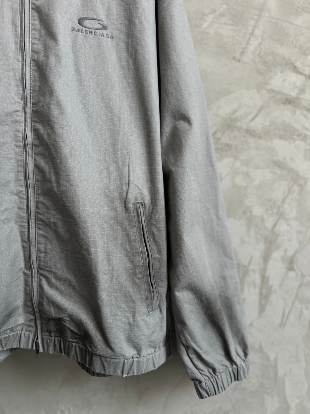 Balenciaga zip-front long jacket in light gray with elastic cuffs and logo patch