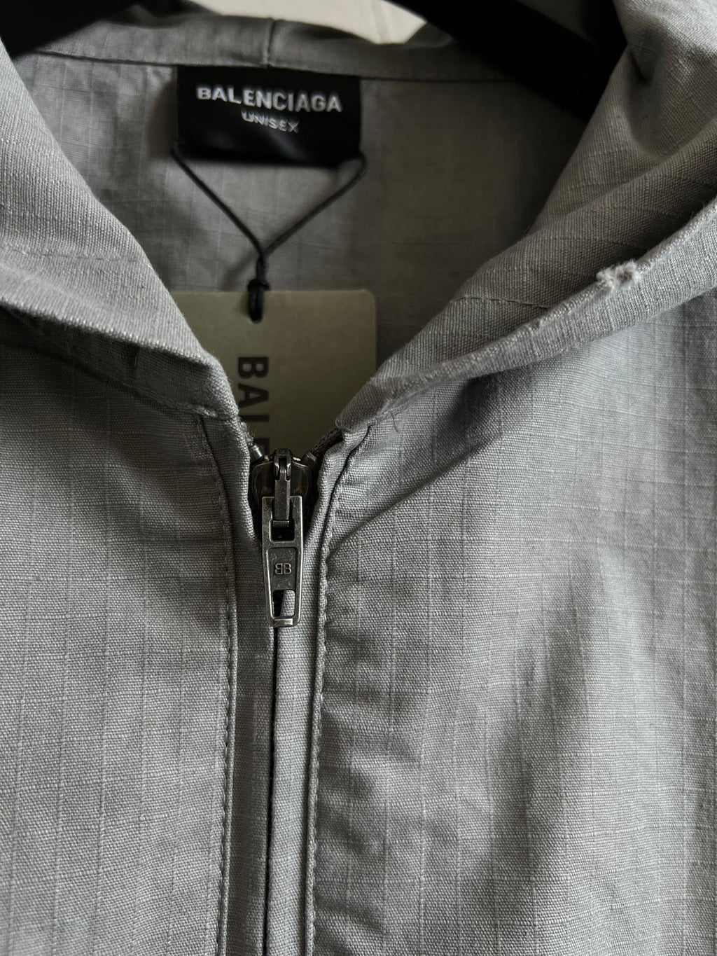 Light gray hooded jacket with front zipper and zipper pull hardware