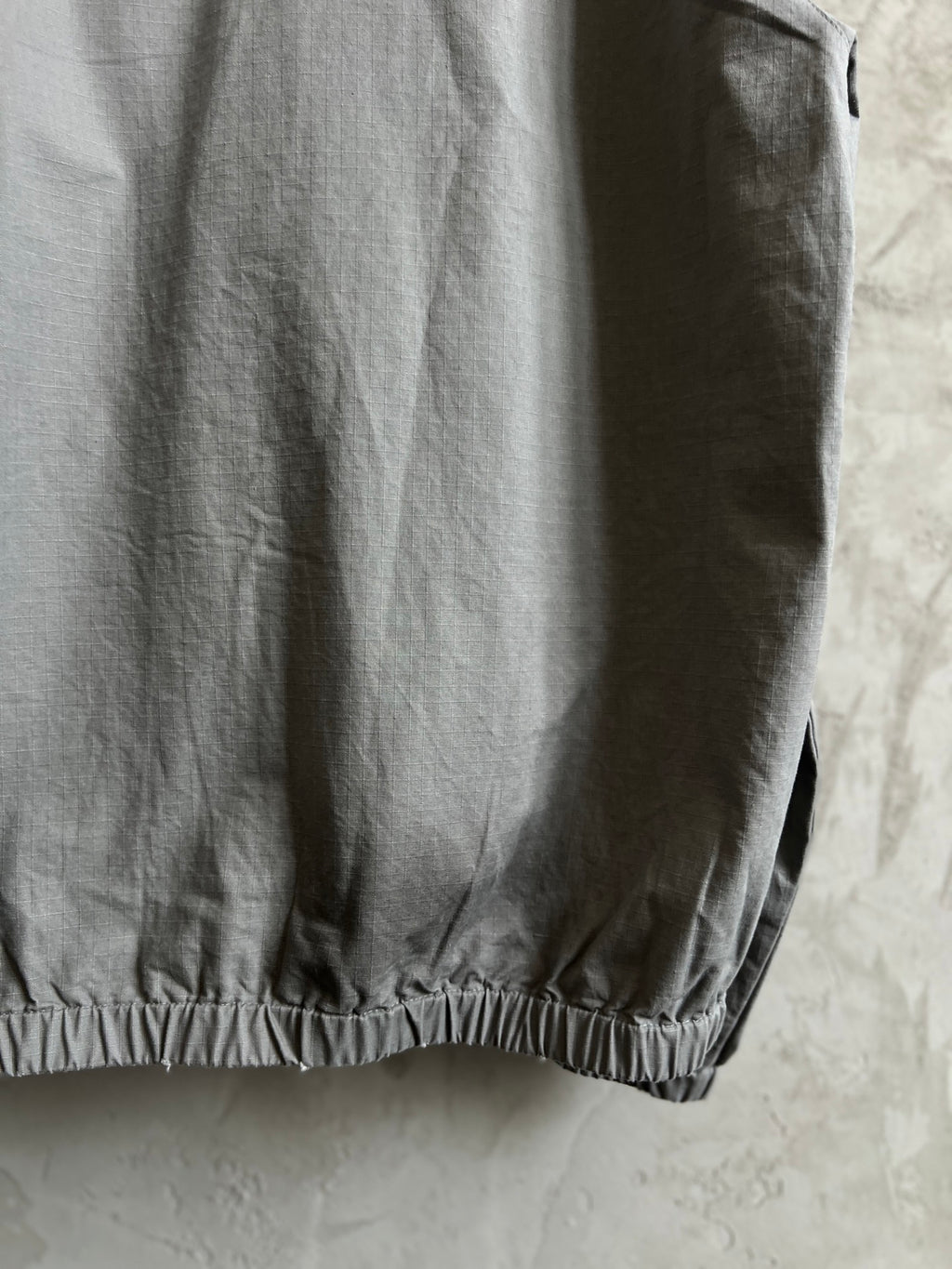 Light gray hooded jacket side view with elastic hem detail