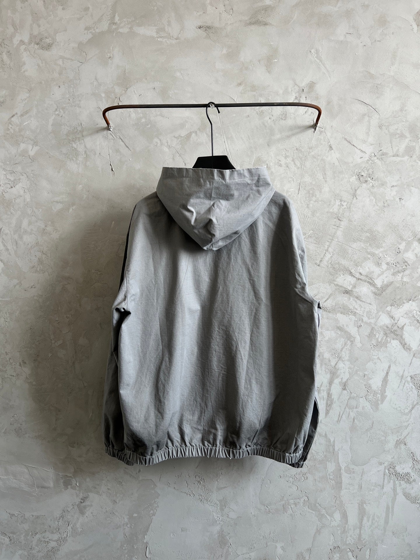 Light gray hooded zip jacket, back view with pockets and drawstring