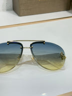 Close-up of metal sunglasses with blue gradient lenses and gold-tone frame