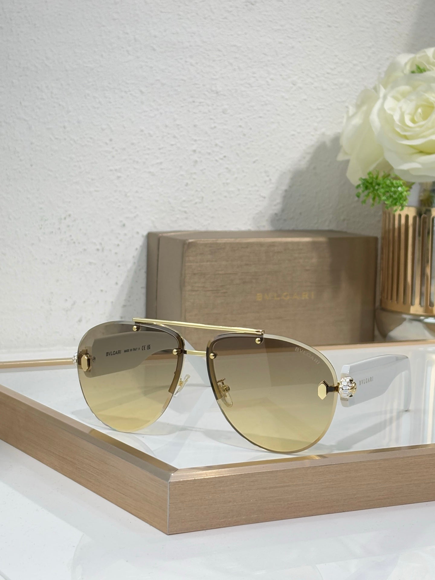 Gold-tone sunglasses with pale yellow gradient lenses and jeweled side detail
