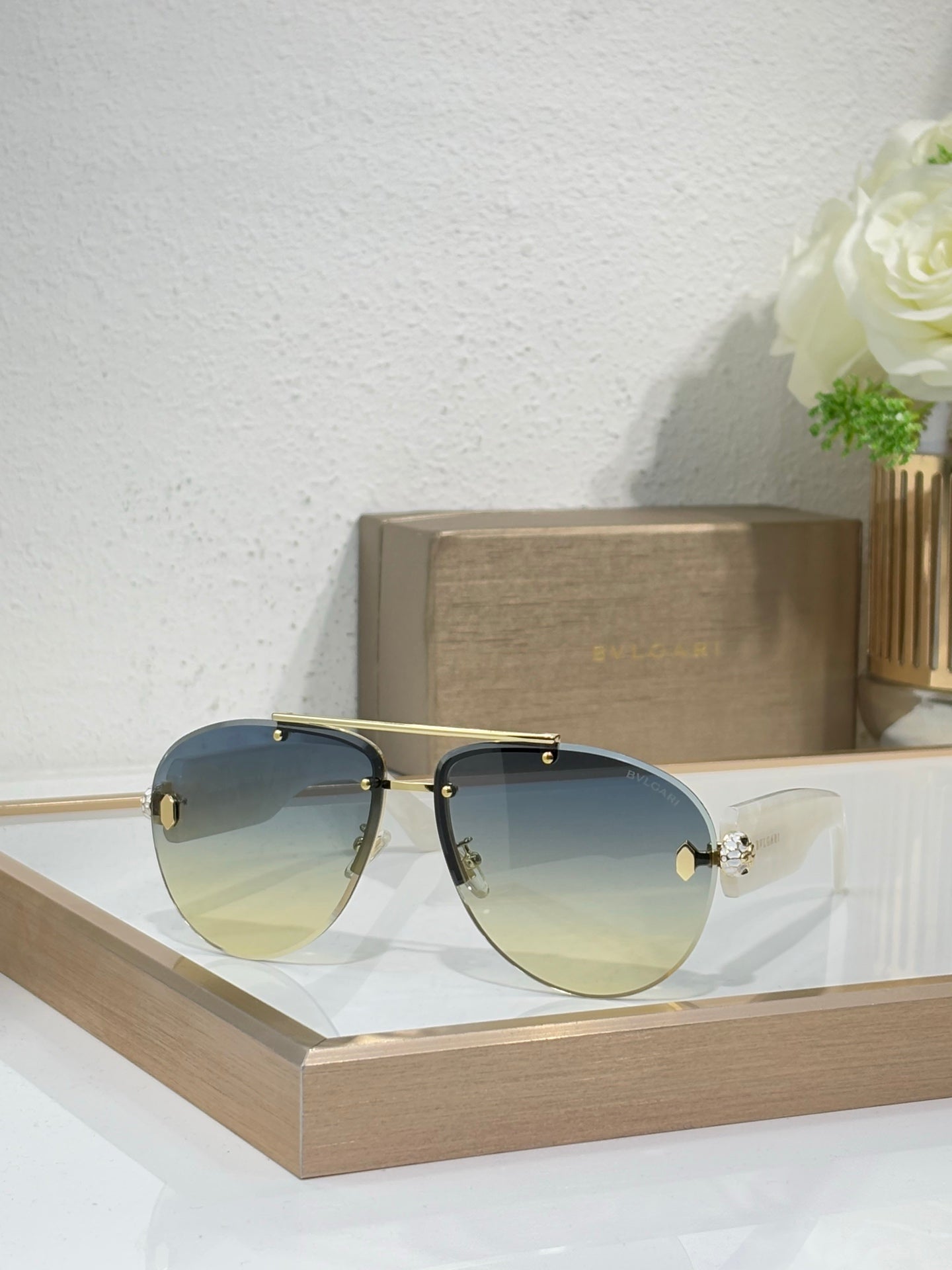 Dark metal sunglasses with blue gradient lenses and gold-tone bridge details