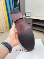 Versace loafer sole view with dark patterned tread and maroon interior side
