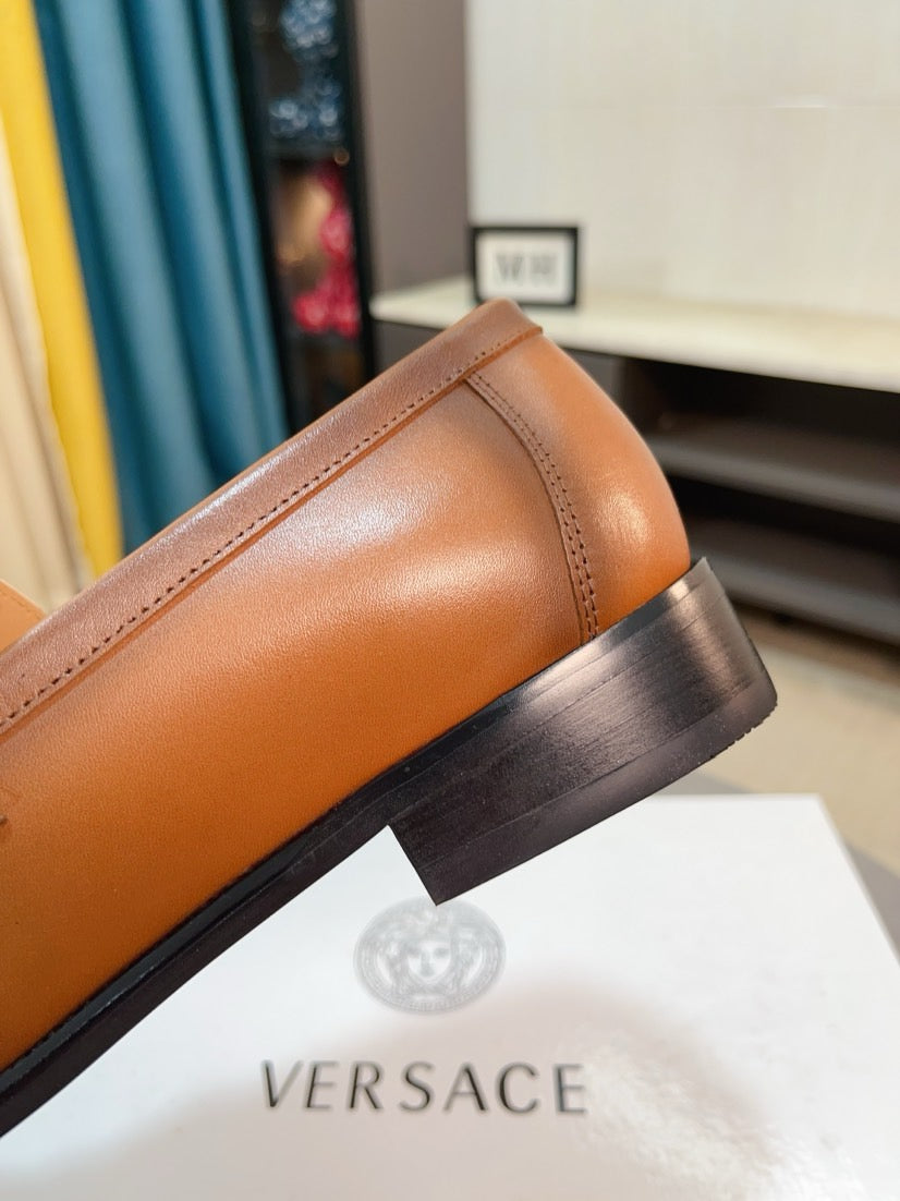 Versace leather loafer side view with tan-brown upper and dark rubber sole