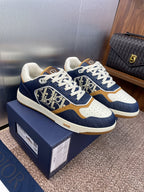 Dior unisex sneakers on box, navy denim with white laces and tan/gold trim