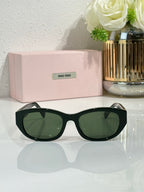 MiuMiu sunglasses with dark frames and green tinted lenses, curved oversized shape