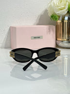MiuMiu cat-eye sunglasses, rear side view, black temples with gold logo details
