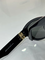 MiuMiu sunglasses temple close-up, black arm with gold clasp hardware
