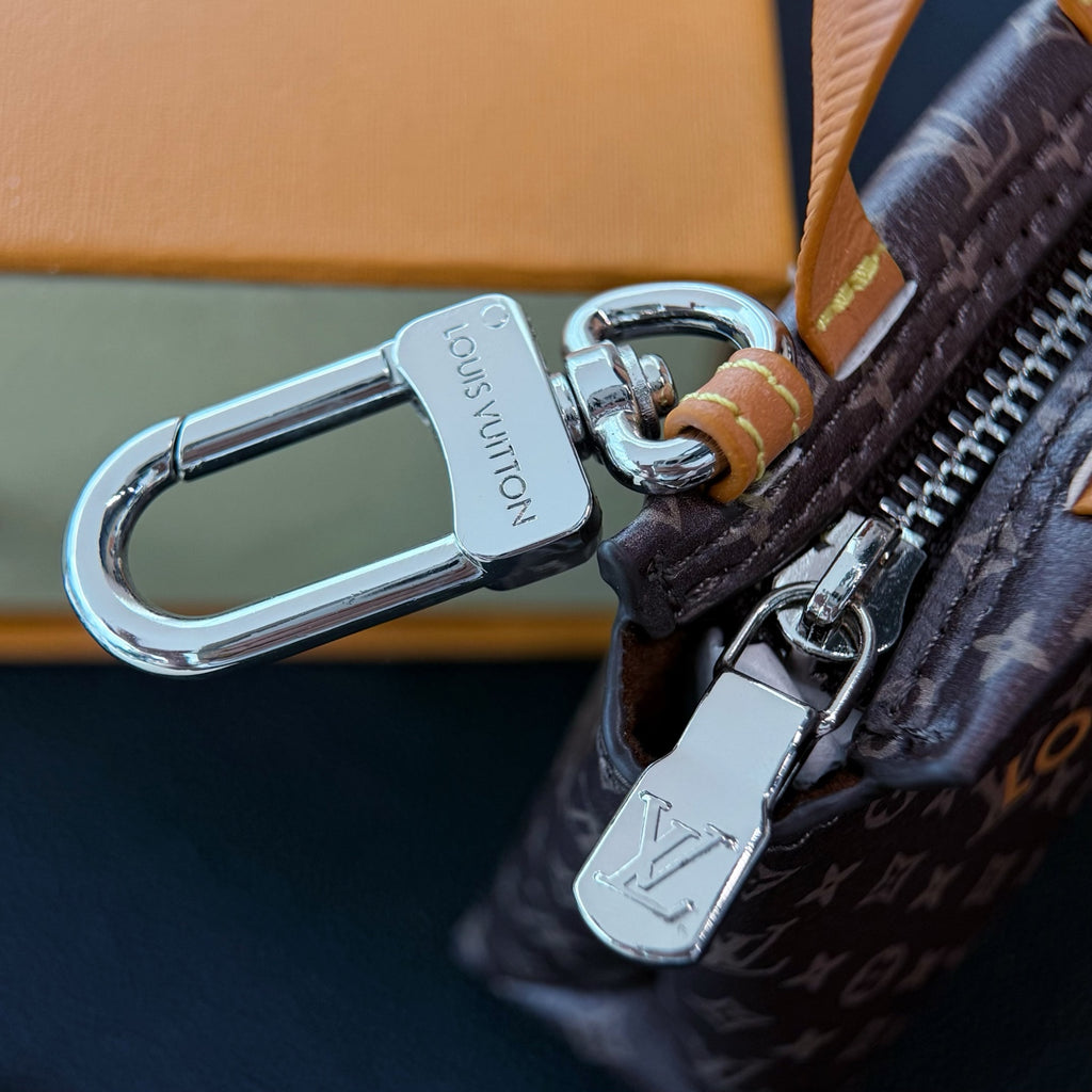 Small Louis Vuitton key clip and silver clasp on dark brown monogram zipper bag