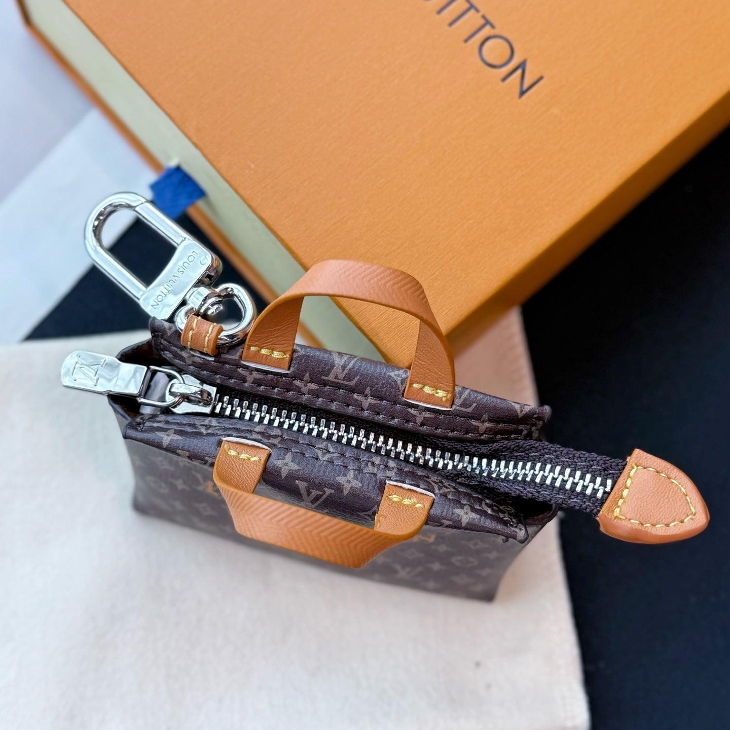 Small Louis Vuitton monogram mini bag with open zipper and tan side strap