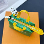Louis Vuitton small bag with green zipper pouch, yellow wrist strap, and silver zipper pull