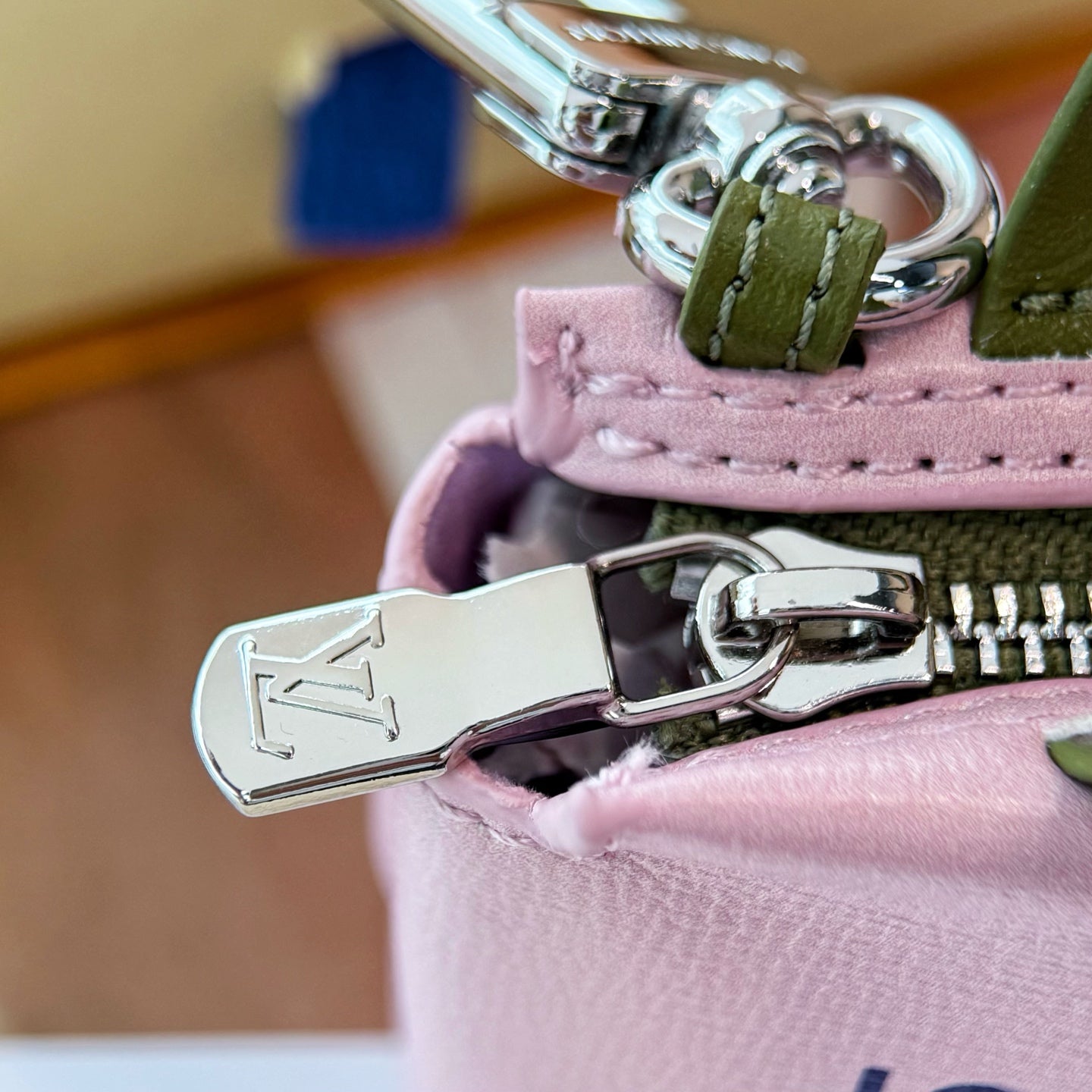 Pink small bag hardware key clasp with silver metal ring and green strap loop.