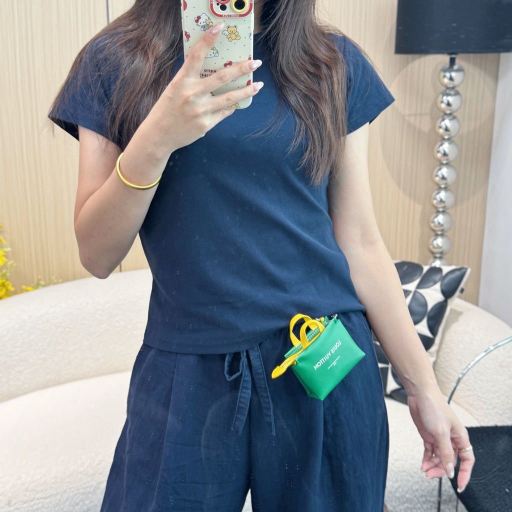 Green mini pouch bag with yellow cord, clipped to waistband