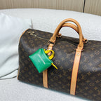 Brown monogram small duffel bag with tan trim and green mini pouch charm