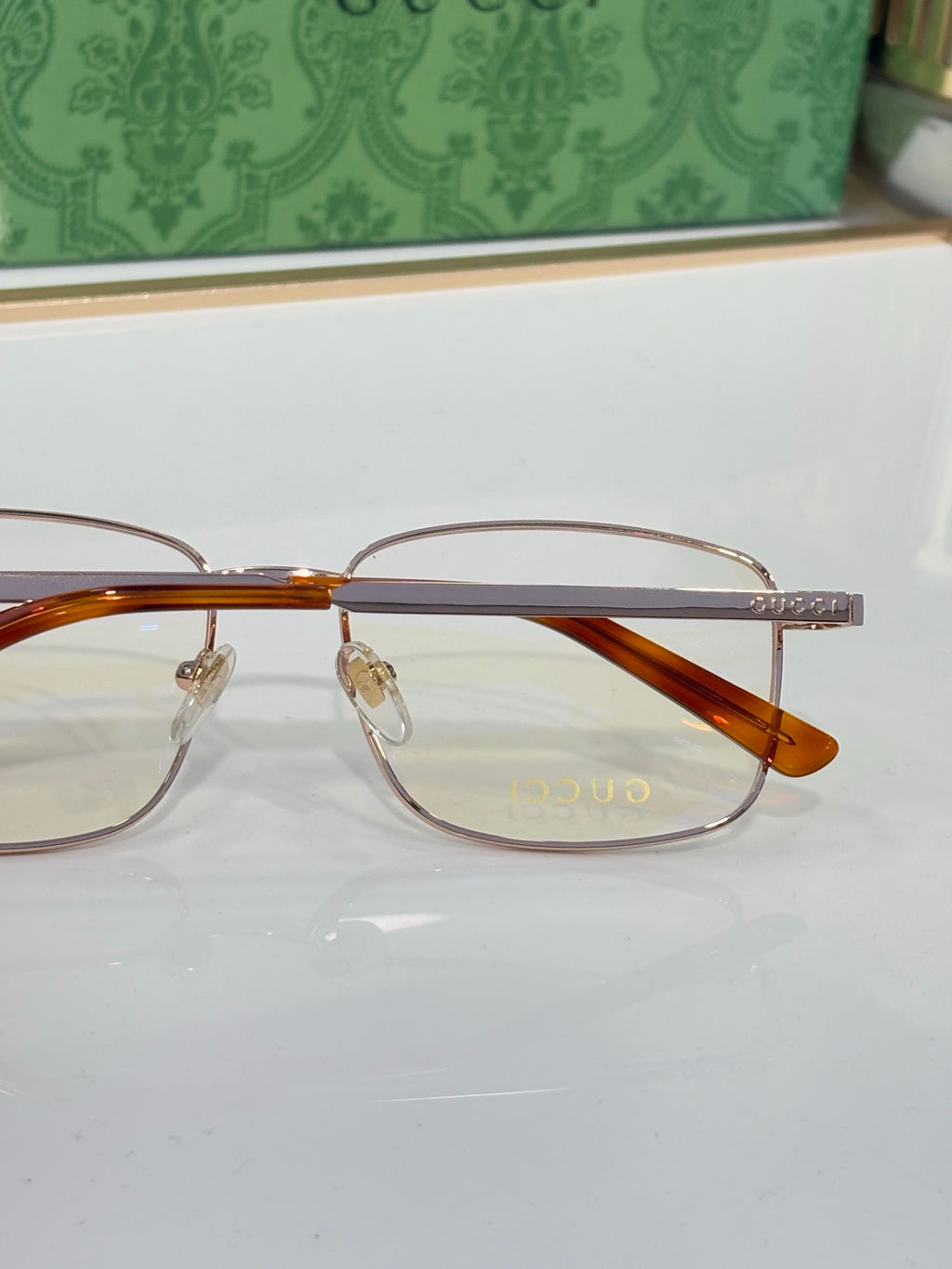Eyeglasses with clear lenses, amber-brown acetate bridge, and thin gold temples