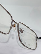 Eyeglasses close-up with silver metal oval frame and small logo emblem at hinge