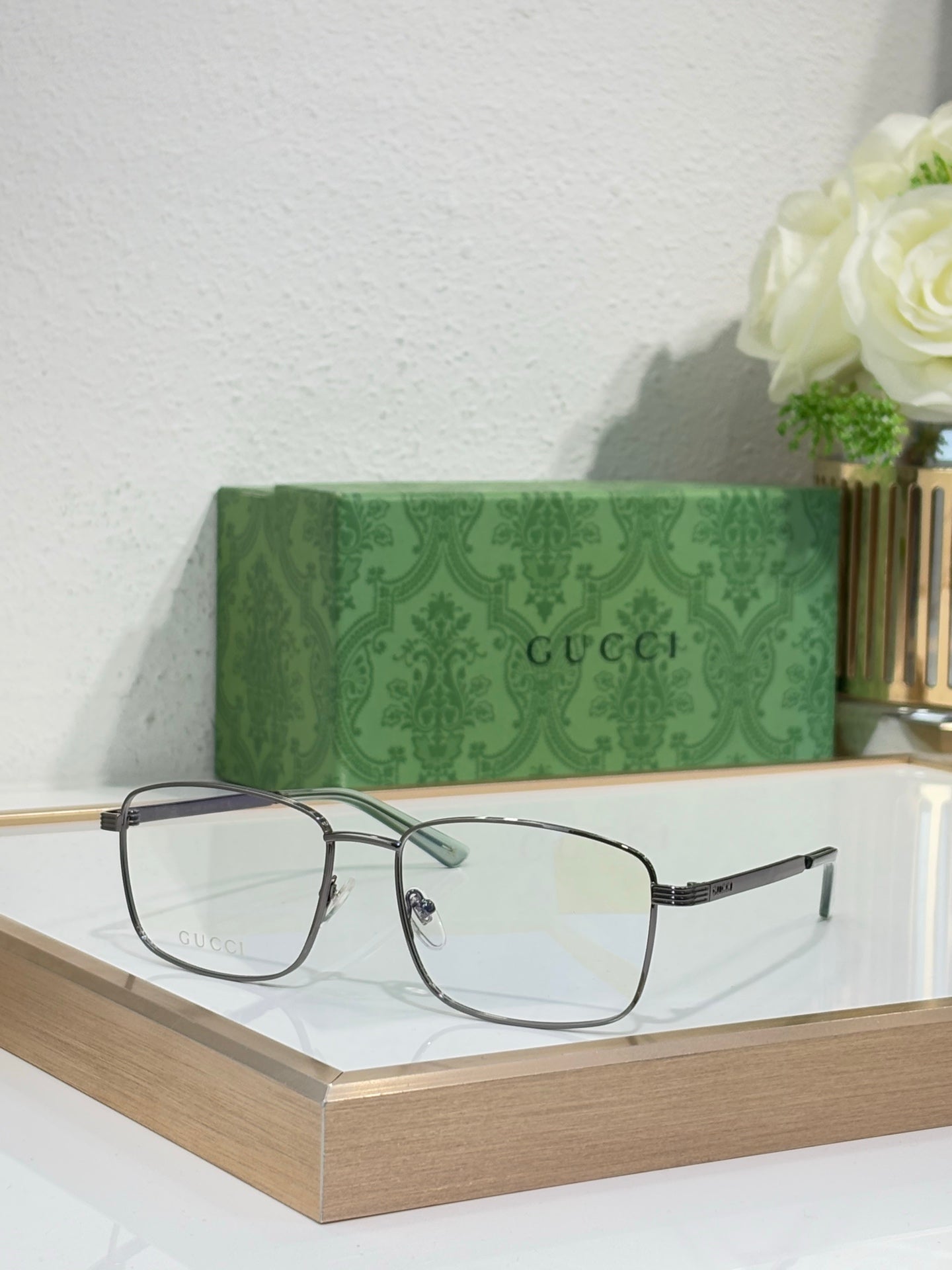 Eyeglasses with gold metal rectangular frame and dark gray temple arms