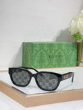Gucci sunglasses with black frames and dark tinted lenses; squared, curved silhouette.