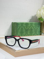 Gucci sunglasses with black frames and clear lenses; burgundy temple details.