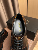Prada leather lace-up shoe front, dark brown, with yellow PRADA logo on lining