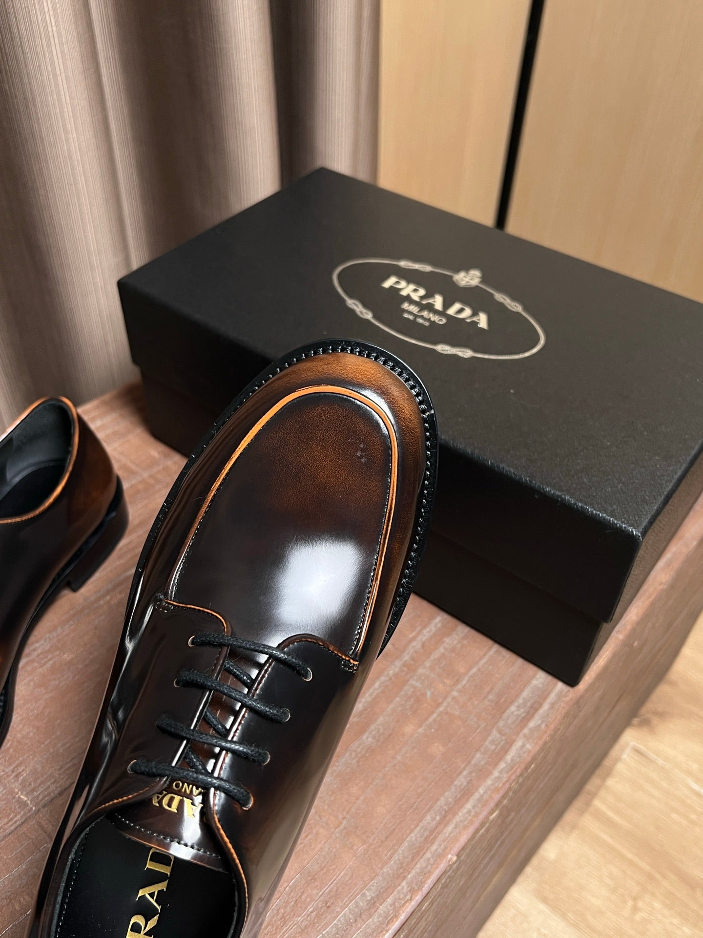 Prada unisex leather derby shoe, dark brown glossy upper and black lace stitching