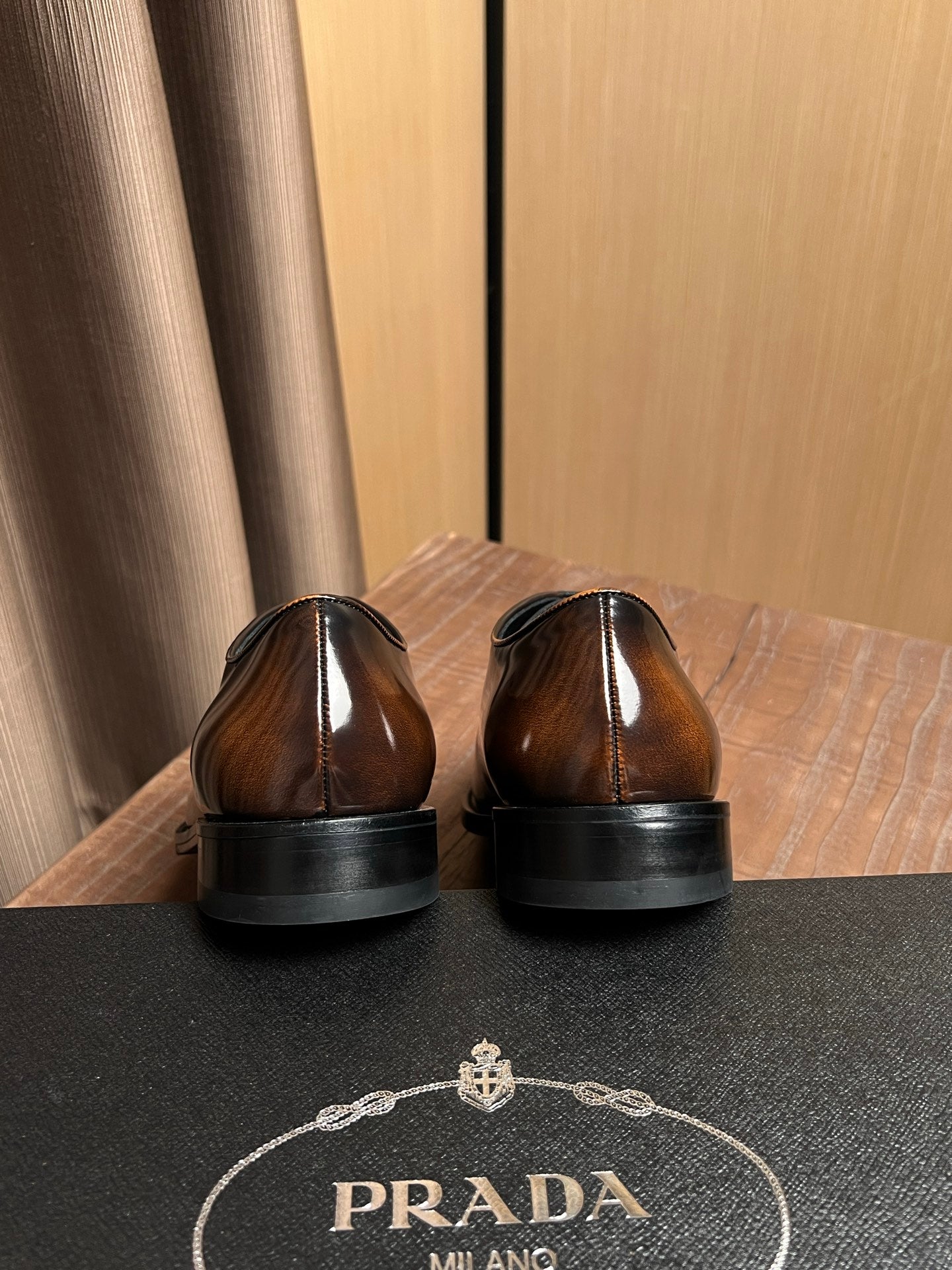 Shoe heels and back view with Prada logo on insole, dark brown leather