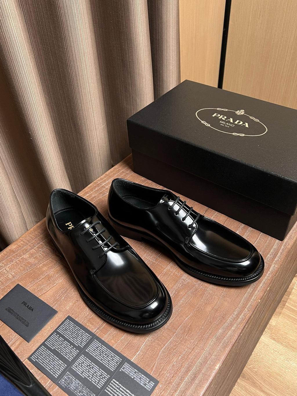 Prada unisex black leather lace-up oxfords, side view pair on display