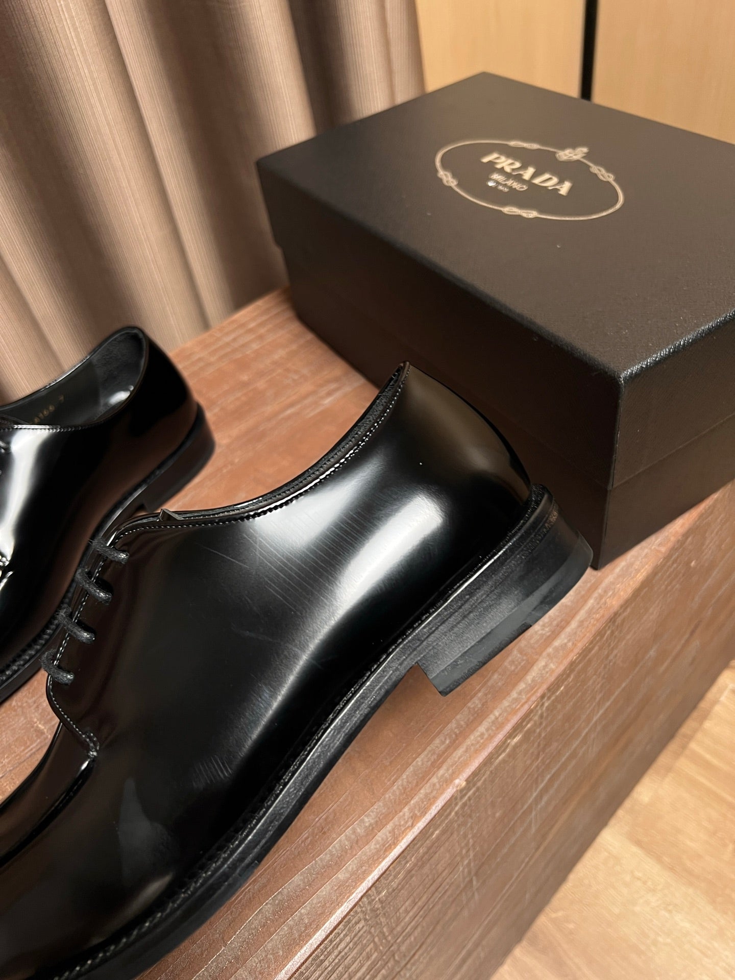 Prada unisex black leather lace-up oxfords, close-up side with lace and sole
