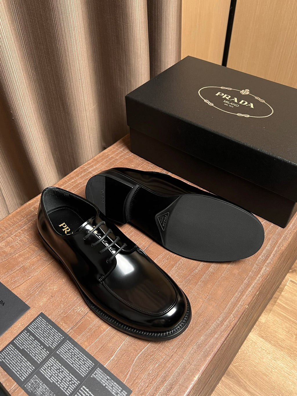 Prada unisex black leather lace-up oxfords, top view of one shoe and insole