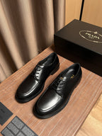 Black leather lace-up dress shoes with laces and side logo detail