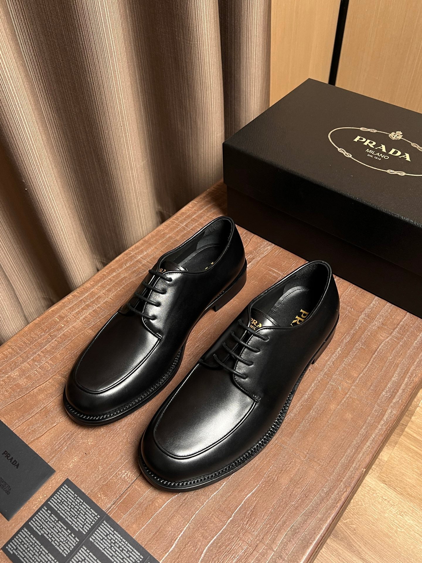 Black leather lace-up dress shoes with laces and side logo detail