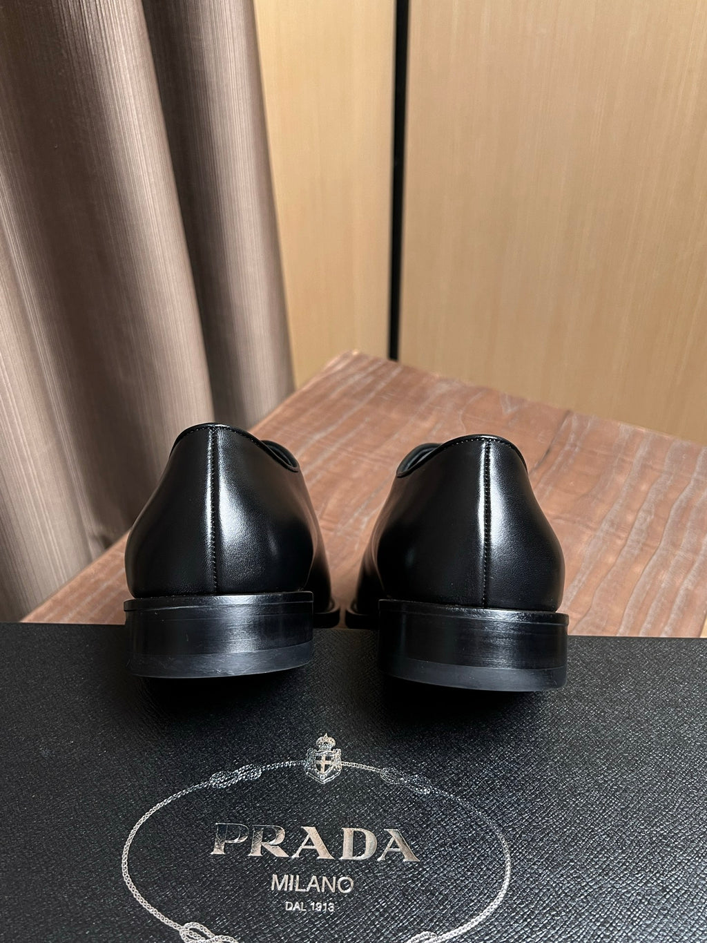 Black leather dress shoes with rear sole view and cushioned heel