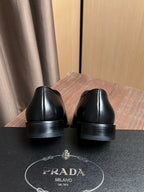 Black leather dress shoes with rear sole view and cushioned heel