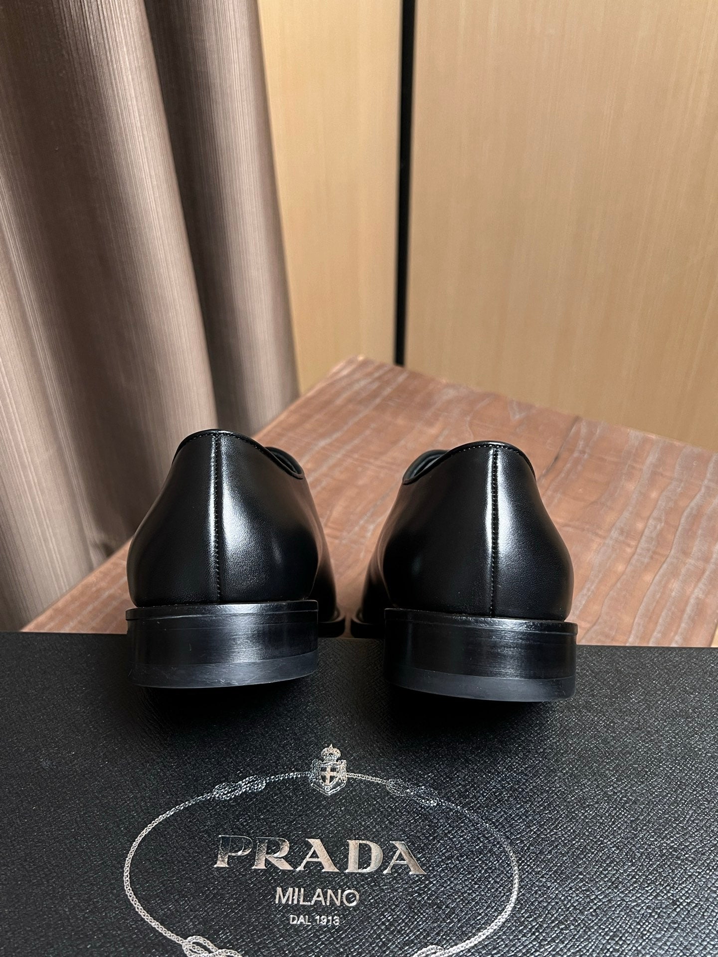 Black leather dress shoes with rear sole view and cushioned heel