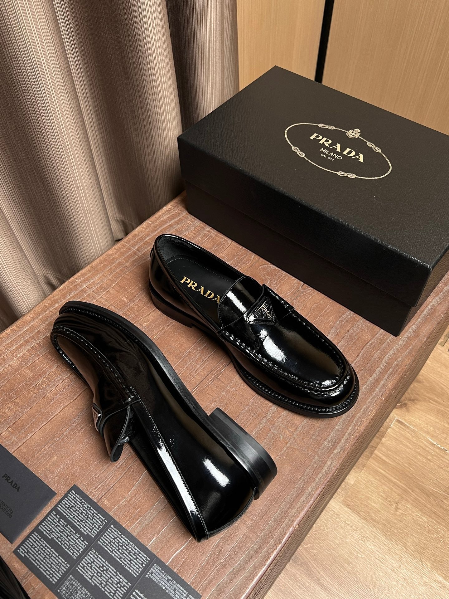 Black patent leather loafers with low stacked heel and detailed stitching