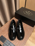 Black patent leather loafers with Prada logo on the vamp
