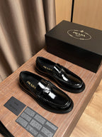 Black patent leather loafers, side view with Prada branding details