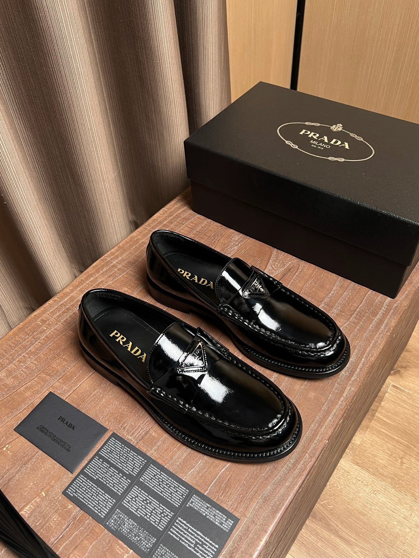 Black patent leather loafers, side view with Prada branding details