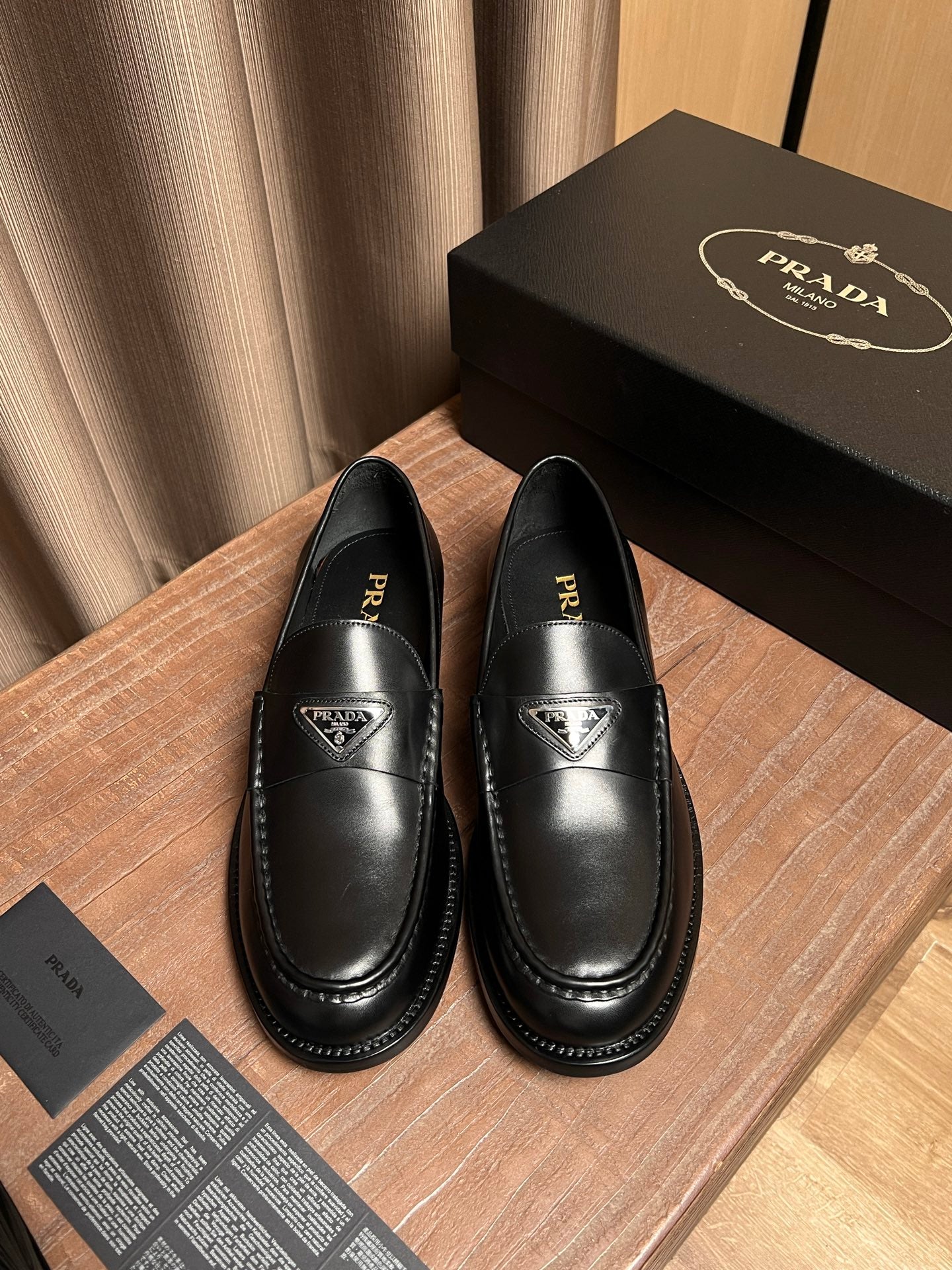 Prada unisex black leather loafers with logo vamp and stitched apron edges