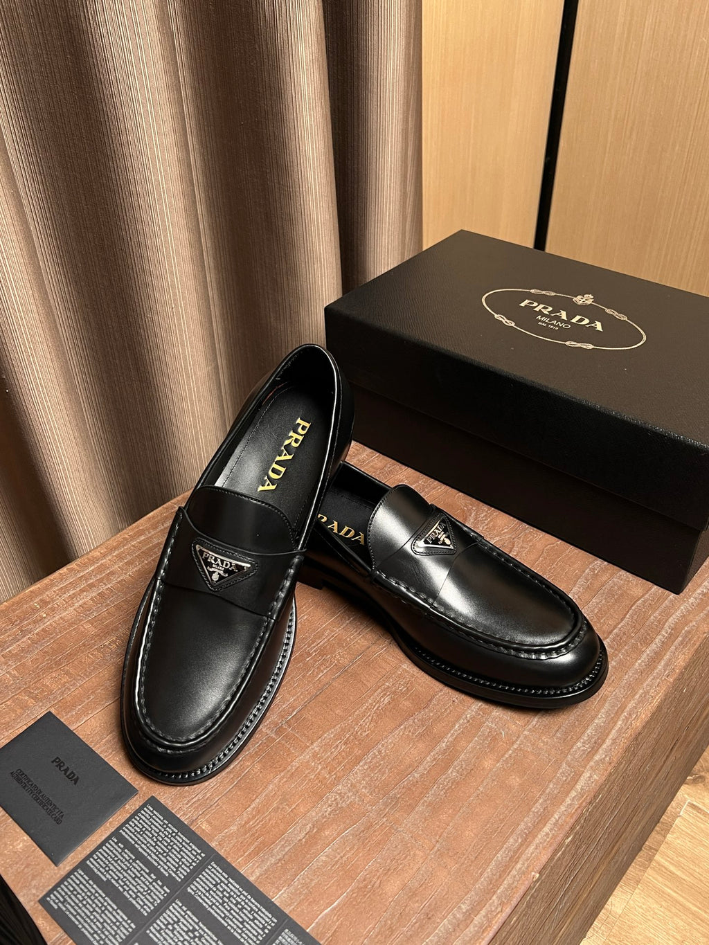Prada unisex black leather loafers with logo patch and side seam stitching