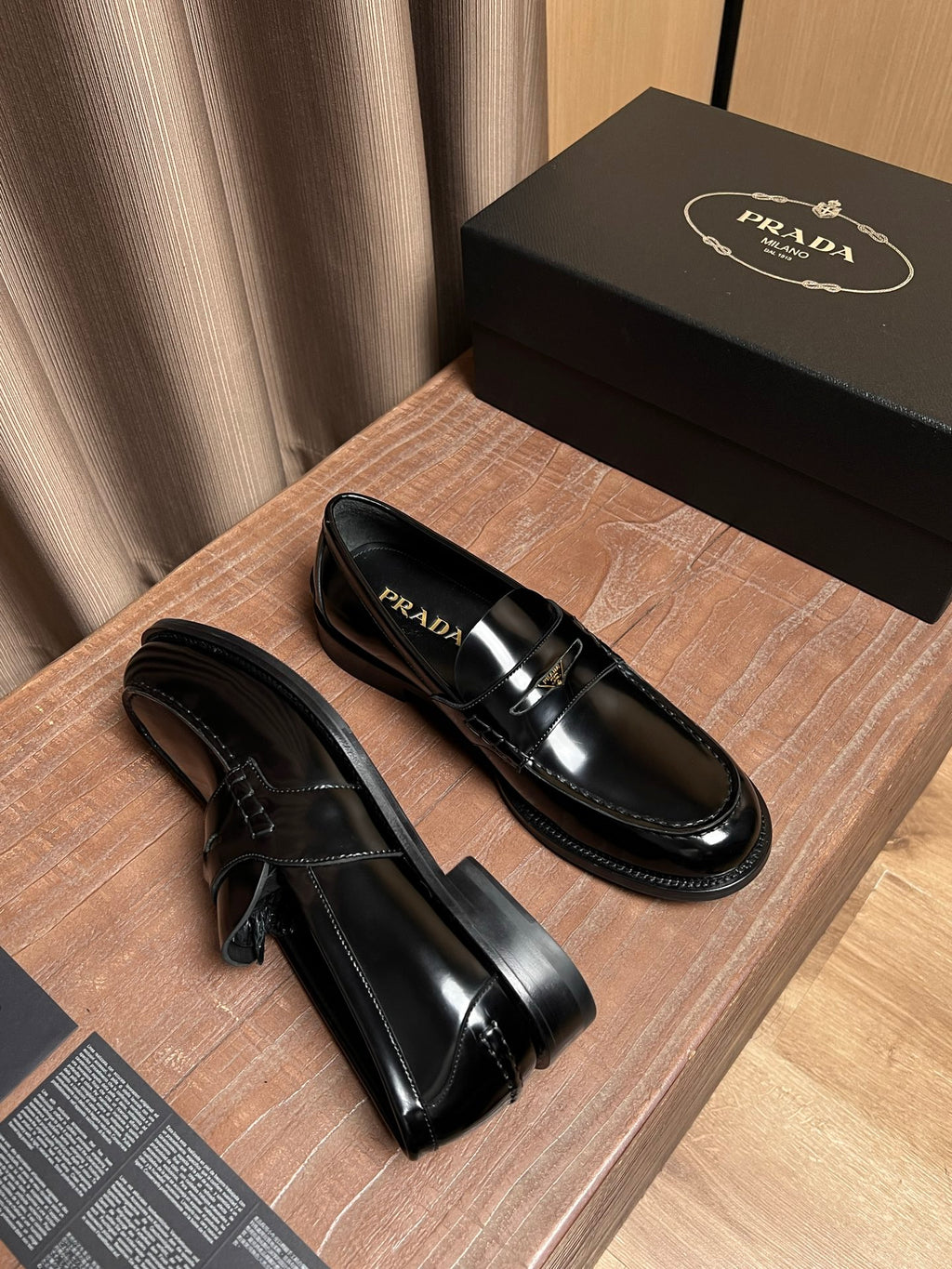 Black leather Prada slip-on loafers, front and side angle